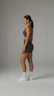 A close-up of brown Sculpt+ Scrunch-Bum Shorts by AIRE, showcasing the sculpting fabric and scrunch detail at the back.