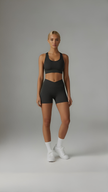 Black Sculpt+ Scrunch-Bum Shorts by AIRE showing high-waisted design and ruched back detail on a white background