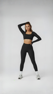 Woman wearing black long sleeve crop top and high-waisted leggings, athleisure outfit