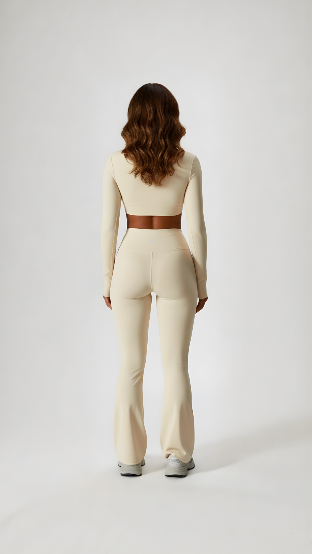 Woman wearing beige long sleeve athleisure set, full length, back view