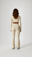 Woman wearing beige long sleeve athleisure set, full length, back view