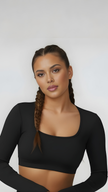 Woman wearing black long sleeve crop top with scoop neck, athleisure activewear style