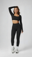 Woman wearing black long sleeve crop top and high-waisted leggings athleisure set