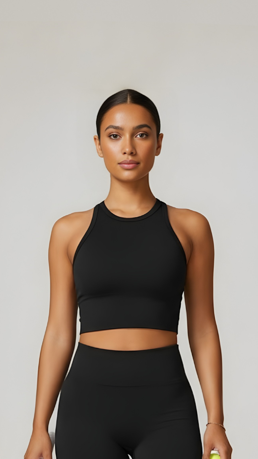 AIRE seamless high-neck top in black, showcasing a close-up view of its smooth, stretchy fabric and sleek design.